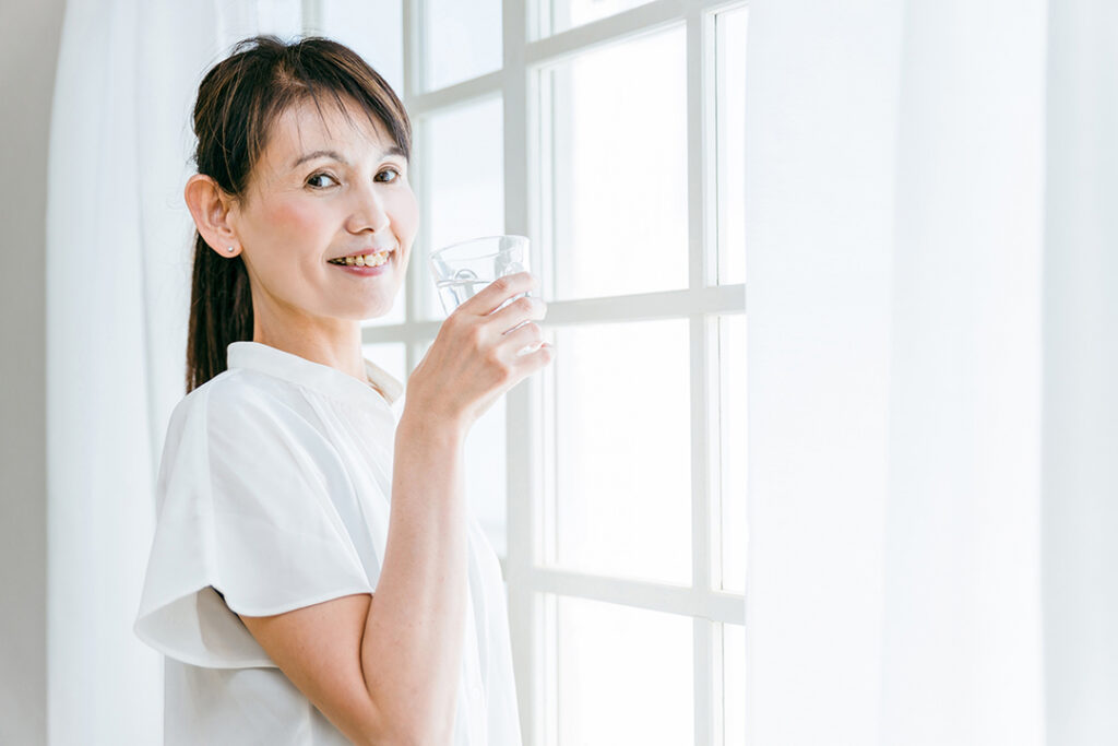 窓でドリンクを飲む女性